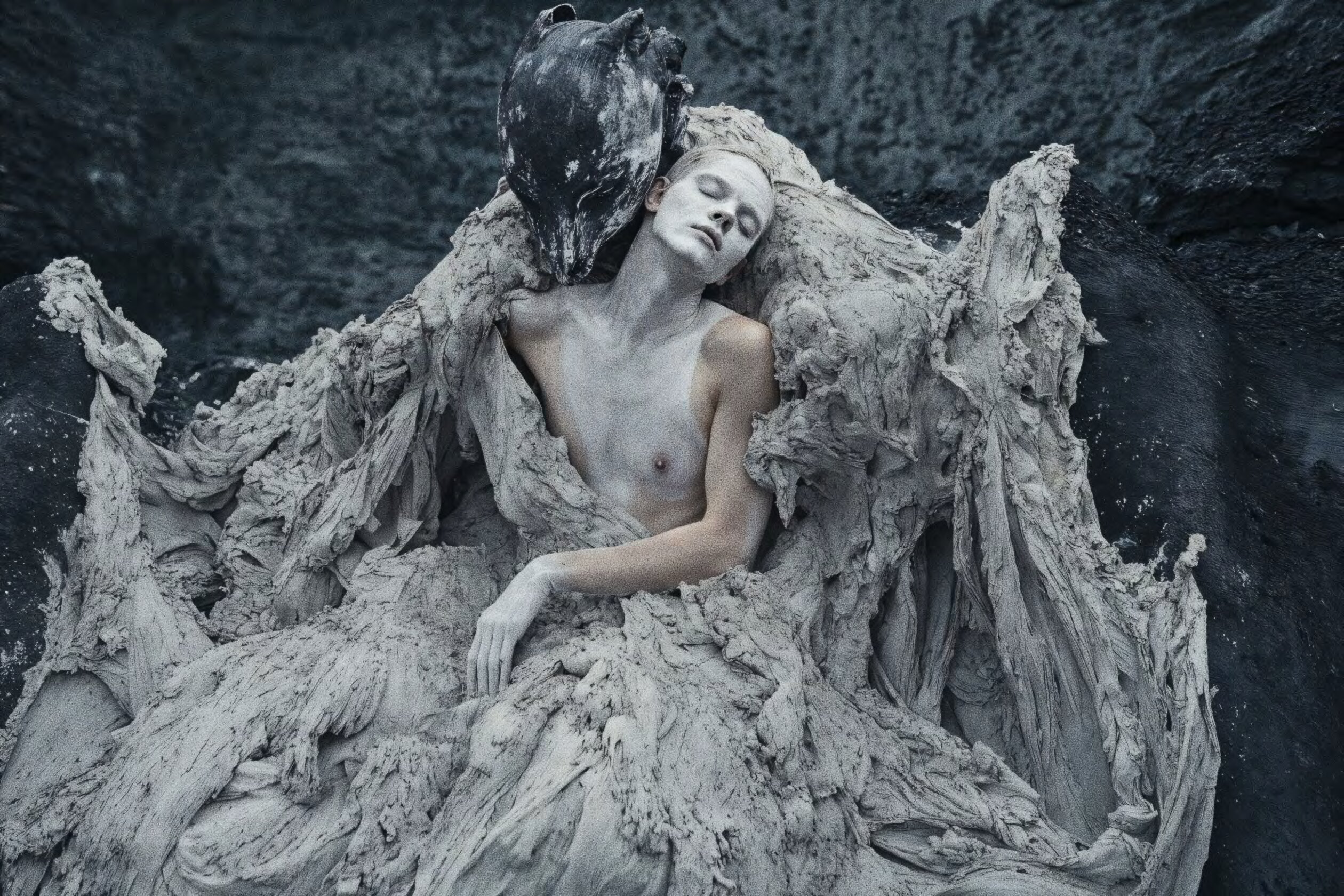 Figure cradled in clay